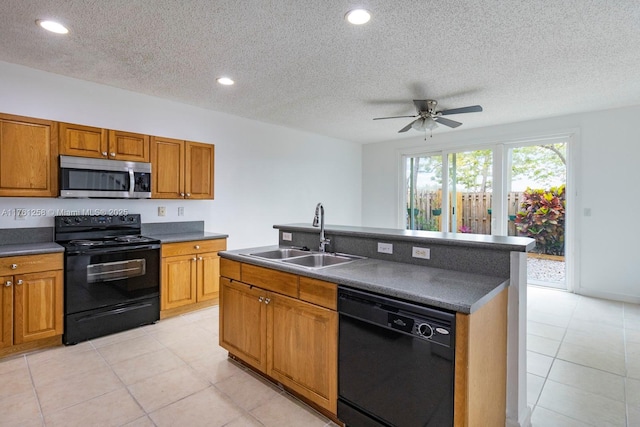 kitchen with dark countertops, recessed lighting, brown cabinets, black appliances, and a sink