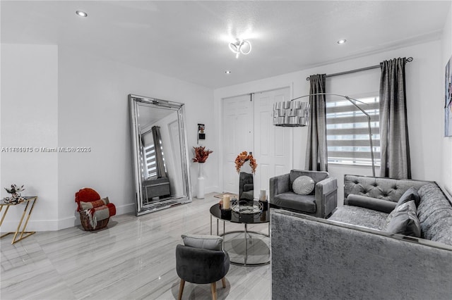 living area featuring recessed lighting and baseboards