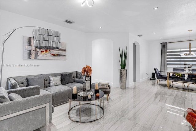 living area with baseboards, visible vents, an inviting chandelier, recessed lighting, and arched walkways