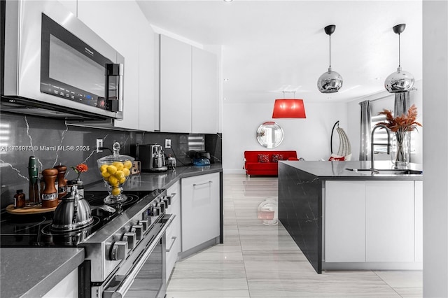 kitchen with a sink, stainless steel microwave, dark countertops, and electric range oven