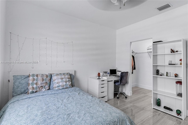 bedroom featuring visible vents, a walk in closet, and a ceiling fan