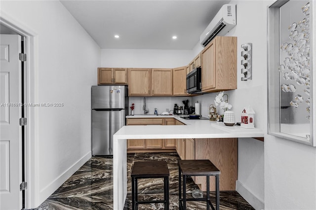 kitchen with a wall mounted AC, light countertops, freestanding refrigerator, and baseboards