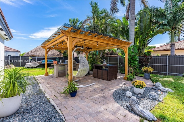 view of patio / terrace with area for grilling, a fenced backyard, a pergola, and outdoor dry bar