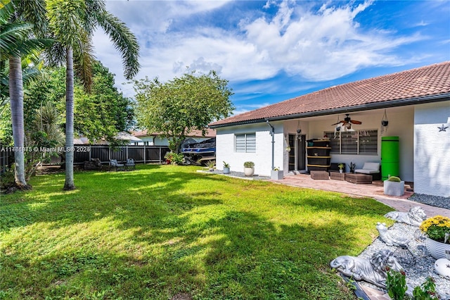 view of yard featuring a patio, fence, and ceiling fan