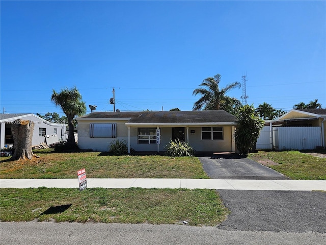 single story home with a front lawn, fence, driveway, and stucco siding