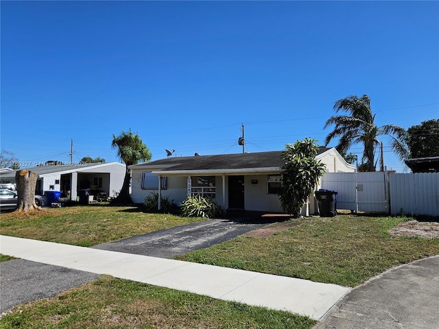 view of front facade featuring a front lawn, a gate, fence, and stucco siding