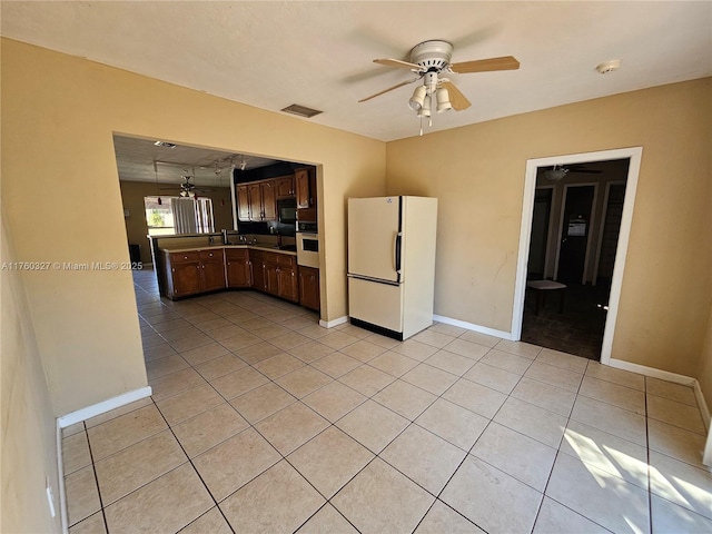 kitchen with visible vents, stainless steel oven, light tile patterned floors, freestanding refrigerator, and a ceiling fan