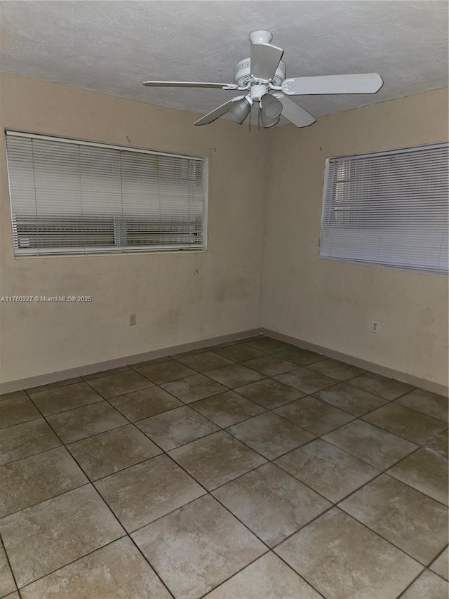 unfurnished room featuring baseboards, a textured ceiling, a ceiling fan, and tile patterned flooring