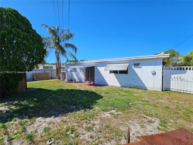 back of property featuring a yard and a fenced backyard