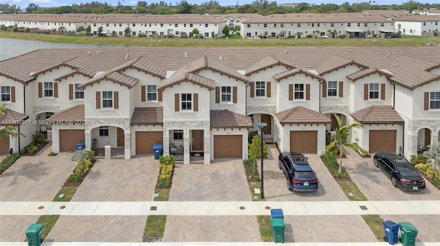 townhome / multi-family property featuring a residential view, a tiled roof, and stone siding