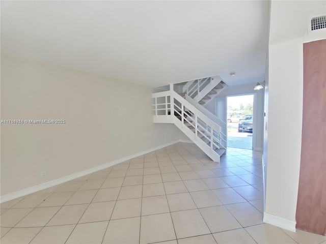 interior space featuring light tile patterned floors, visible vents, stairs, and baseboards