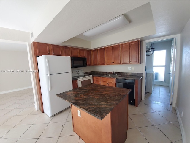 kitchen with light tile patterned floors, black appliances, a tray ceiling, and a sink