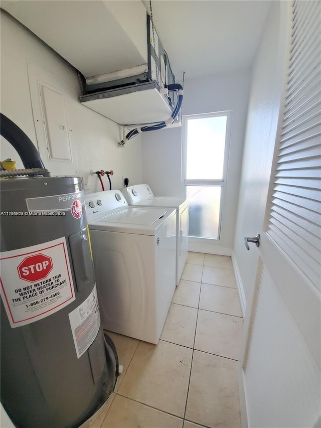 laundry room featuring electric water heater, washer and clothes dryer, light tile patterned floors, laundry area, and a garage