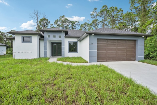 prairie-style home featuring stucco siding, driveway, and an attached garage