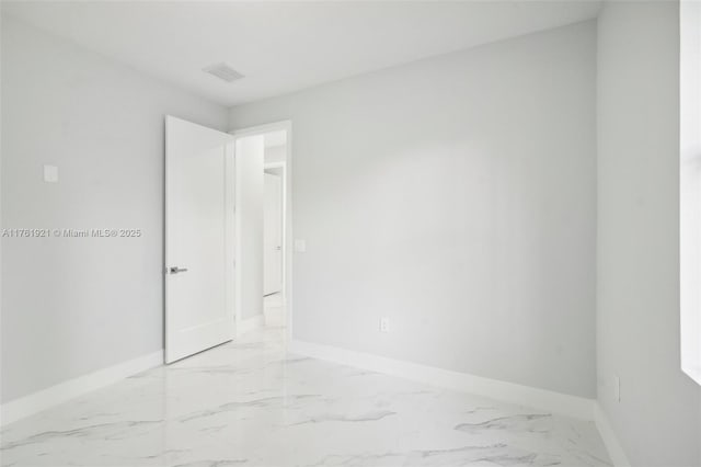 spare room with visible vents, baseboards, and marble finish floor