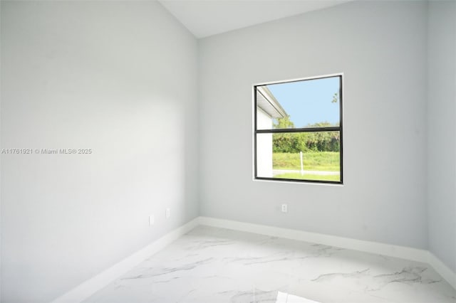 spare room with marble finish floor and baseboards