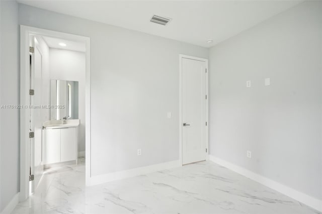 unfurnished bedroom featuring baseboards, visible vents, marble finish floor, and a sink