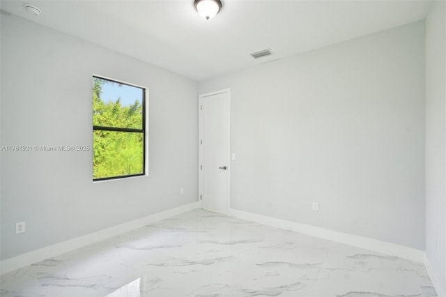 empty room with visible vents, baseboards, and marble finish floor