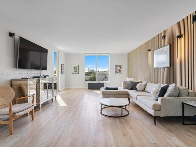 10350 W Bay Harbor Dr Unit 4H, Bay Harbor Islands, FL 33154 - living area with wood walls, light wood finished floors, and baseboards