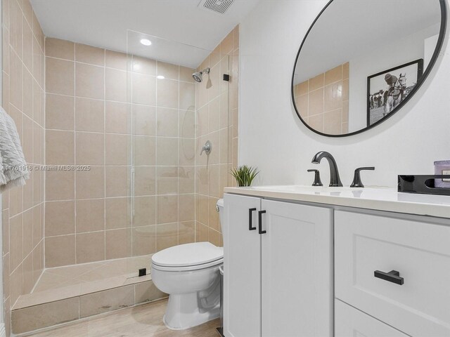 10350 W Bay Harbor Dr Unit 4H, Bay Harbor Islands, FL 33154 - bathroom featuring tiled shower, toilet, visible vents, wood finished floors, and vanity