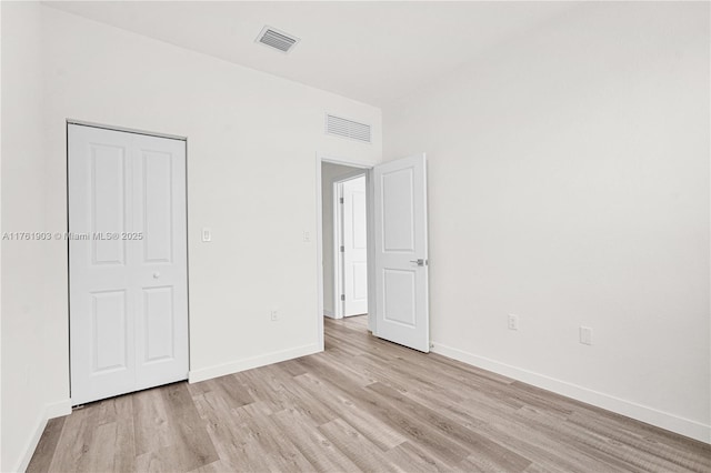 unfurnished bedroom featuring visible vents, baseboards, and light wood-style floors