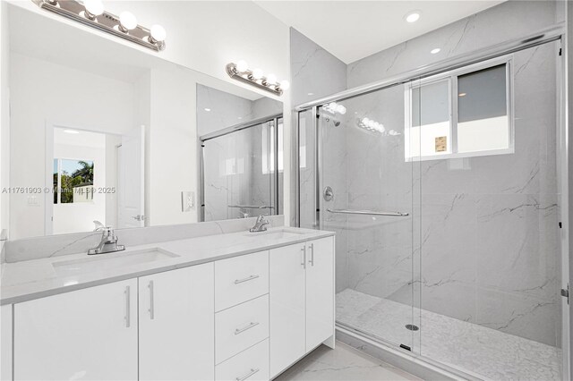 full bathroom featuring marble finish floor, a marble finish shower, and a sink