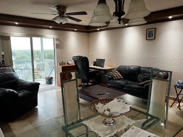 living area with a textured wall and ceiling fan