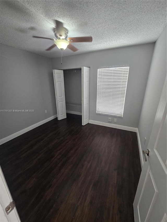 7655 SW 153rd Ct Unit 102, Miami, FL 33193 - unfurnished bedroom with dark wood-style flooring, a textured ceiling, a closet, ceiling fan, and baseboards
