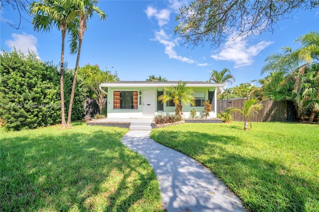 view of front of home featuring stucco siding, a front yard, and fence