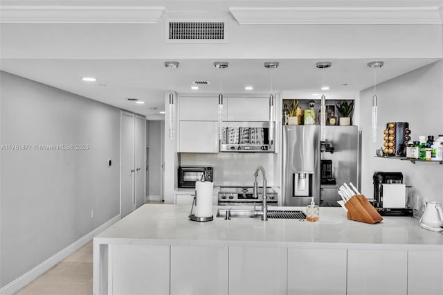 kitchen with visible vents, a sink, light countertops, white cabinetry, and stainless steel fridge