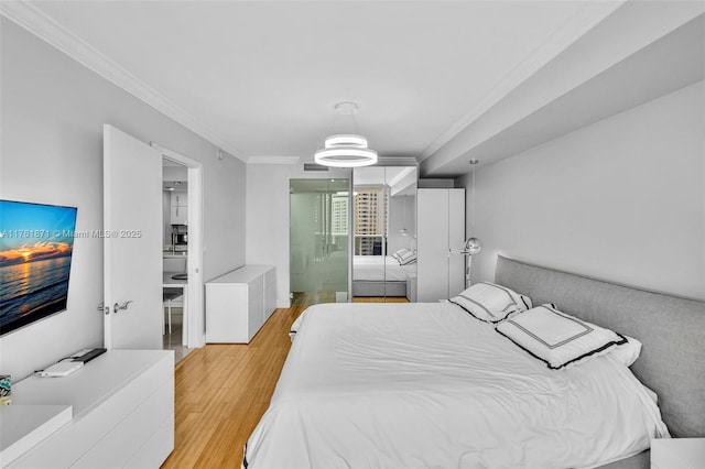 bedroom featuring light wood-style floors and crown molding