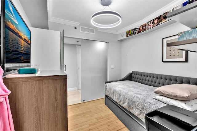 bedroom with visible vents, light wood-type flooring, and crown molding