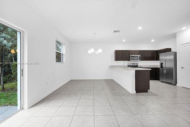 kitchen with visible vents, a peninsula, stainless steel appliances, light countertops, and dark brown cabinets