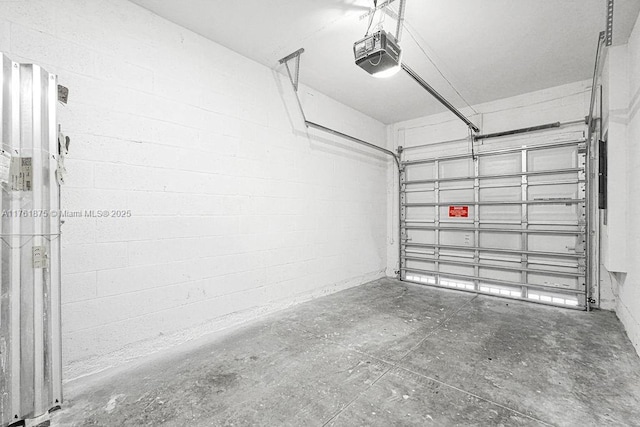 garage with concrete block wall and a garage door opener