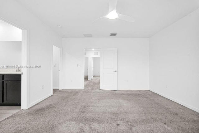 carpeted empty room featuring visible vents, ceiling fan, and baseboards