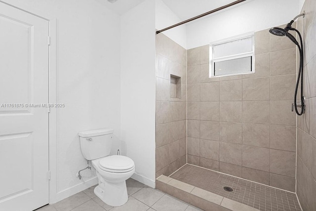 full bathroom with a shower stall, toilet, baseboards, and tile patterned floors