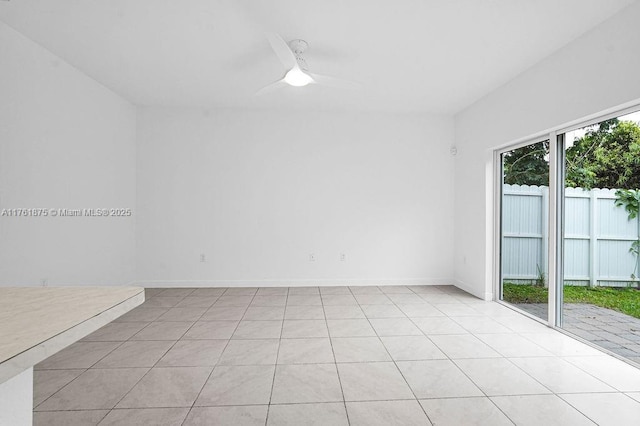 unfurnished room featuring light tile patterned floors, baseboards, and ceiling fan