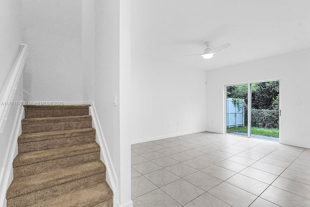 stairway with tile patterned floors, baseboards, and ceiling fan