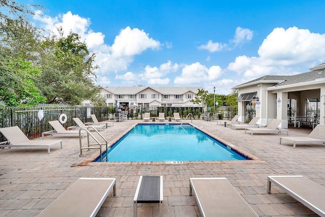 pool with a patio area and fence