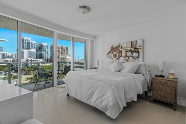 bedroom featuring access to exterior, light tile patterned floors, a view of city, and a wall of windows