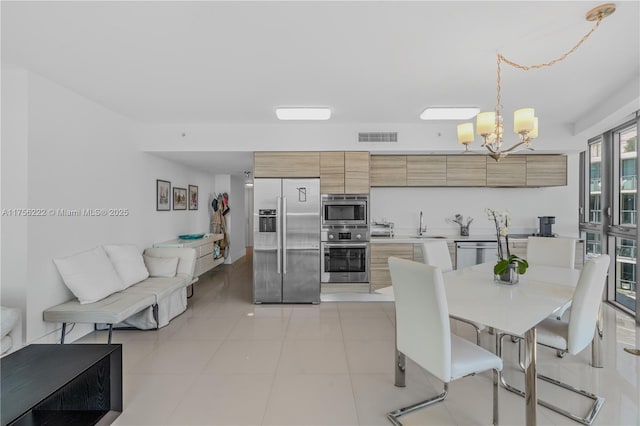 dining room with light tile patterned floors, visible vents, and a chandelier