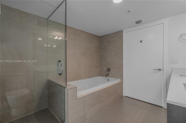 bathroom featuring visible vents, toilet, tiled shower, a bath, and tile patterned floors