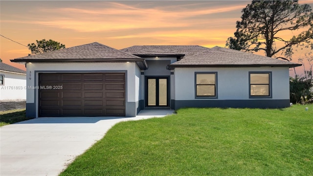 view of front of property featuring a front lawn, an attached garage, concrete driveway, and stucco siding