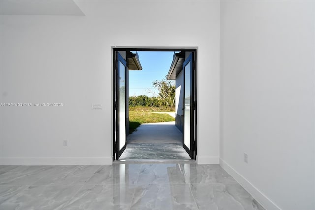 foyer featuring marble finish floor and baseboards