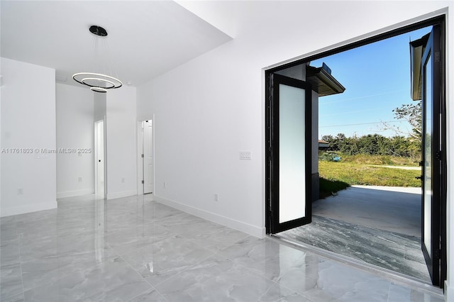 entryway with baseboards and marble finish floor