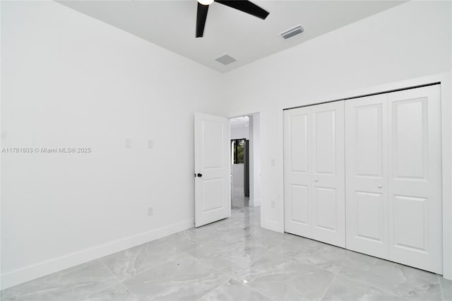 unfurnished bedroom with visible vents, baseboards, a closet, marble finish floor, and a ceiling fan