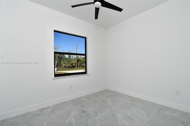 unfurnished room featuring baseboards, marble finish floor, and ceiling fan