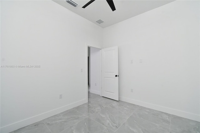 empty room with visible vents, ceiling fan, and baseboards