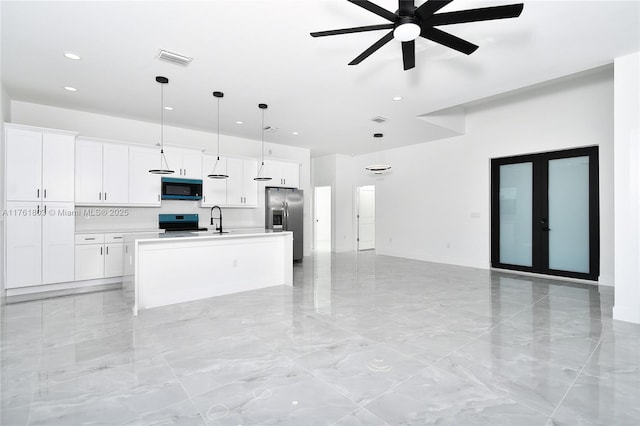 kitchen featuring visible vents, open floor plan, white cabinets, stainless steel appliances, and a sink