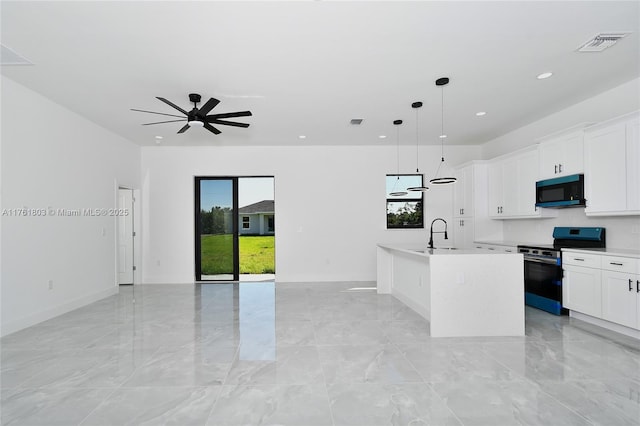 kitchen with a center island with sink, visible vents, a sink, range with electric cooktop, and black microwave